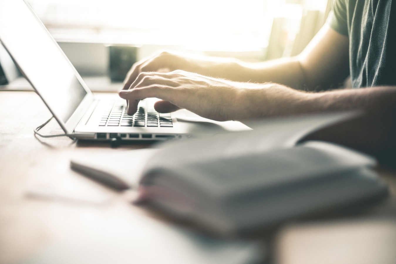 Student arbeitet mit Laptop und Buch