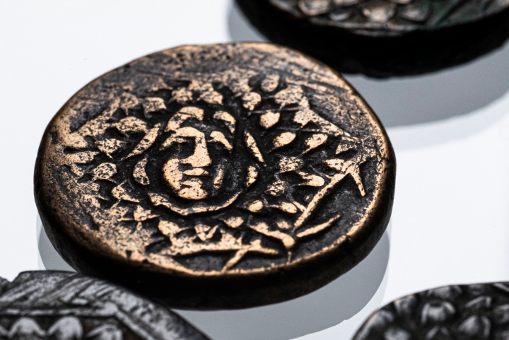 Auf der Vorderseite der Münze das unheilabwehrende Haupt der Medusa auf dem Schild des Perseus, die sog. Aegis